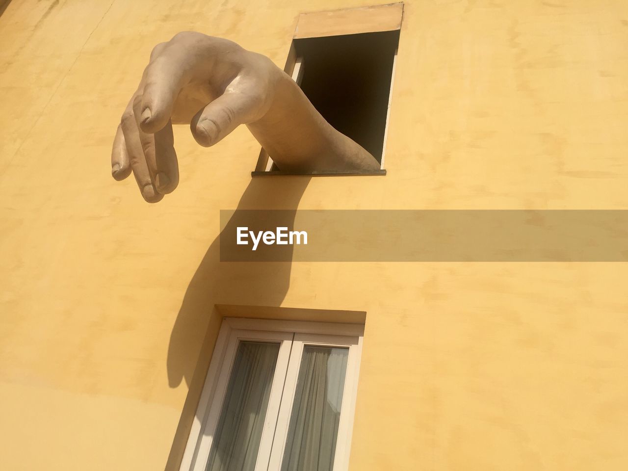 LOW ANGLE VIEW OF MAN HAND ON WINDOW