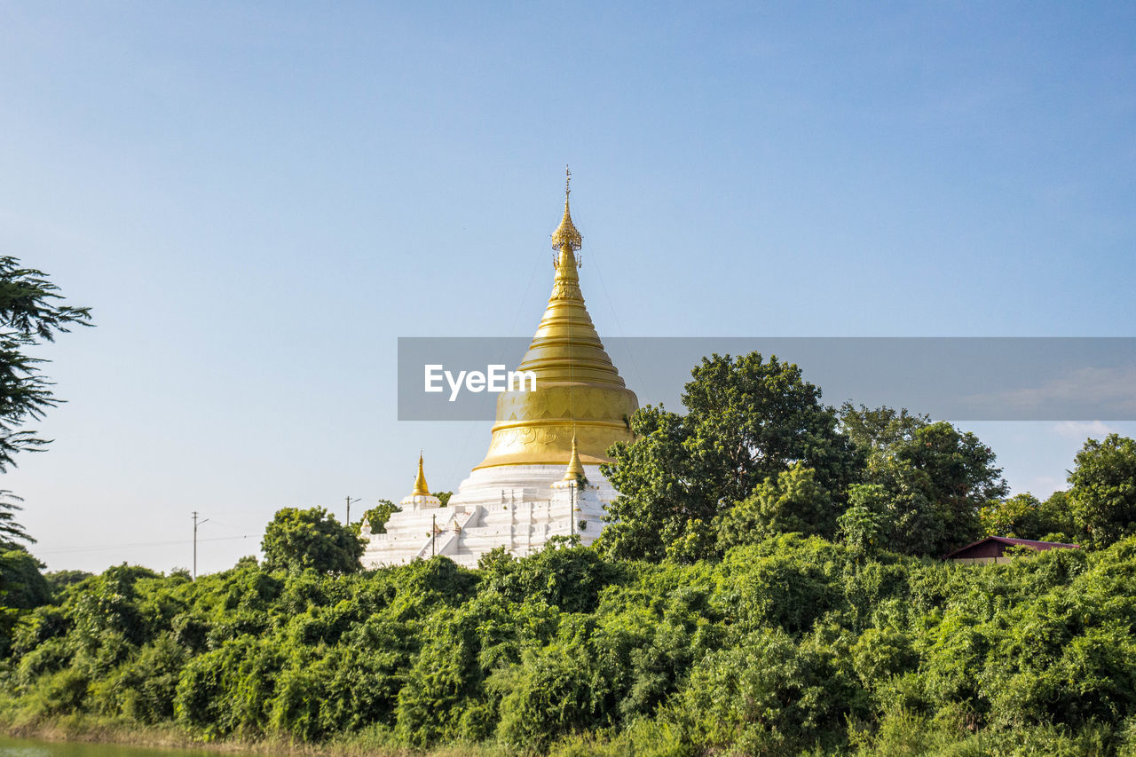 Close-up of pagoda against blue sky and trees