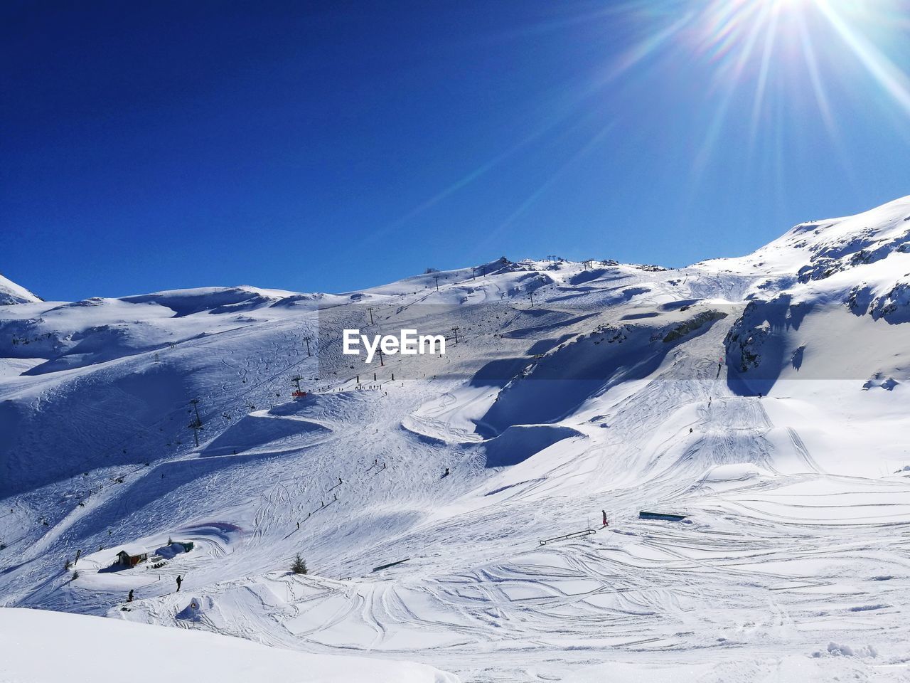 Scenic view of snow covered mountains against clear blue sky