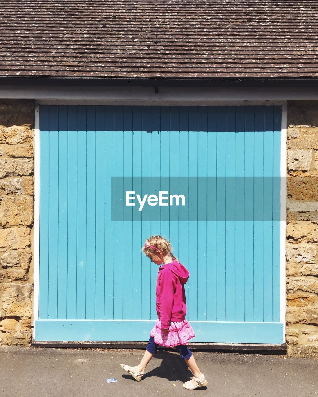 Rear view of girl standing in front of house