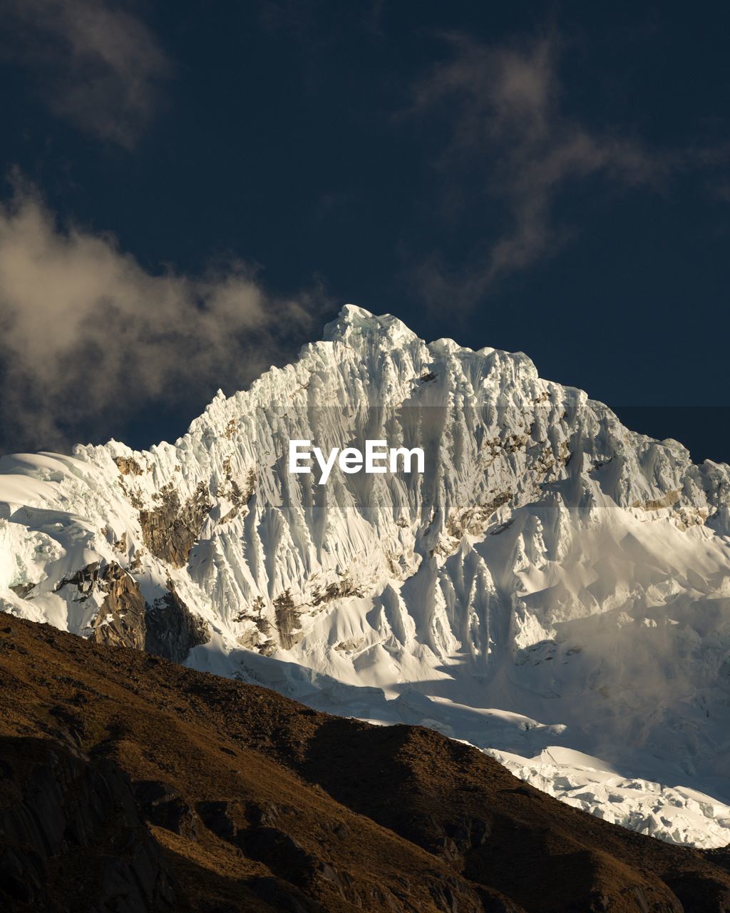 Low angle view of snowcapped mountain against sky