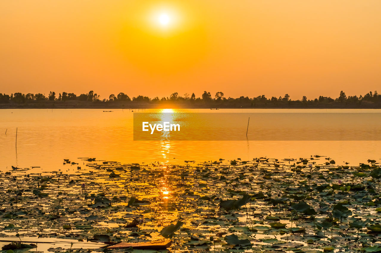 SCENIC VIEW OF LAKE AGAINST SKY AT SUNSET