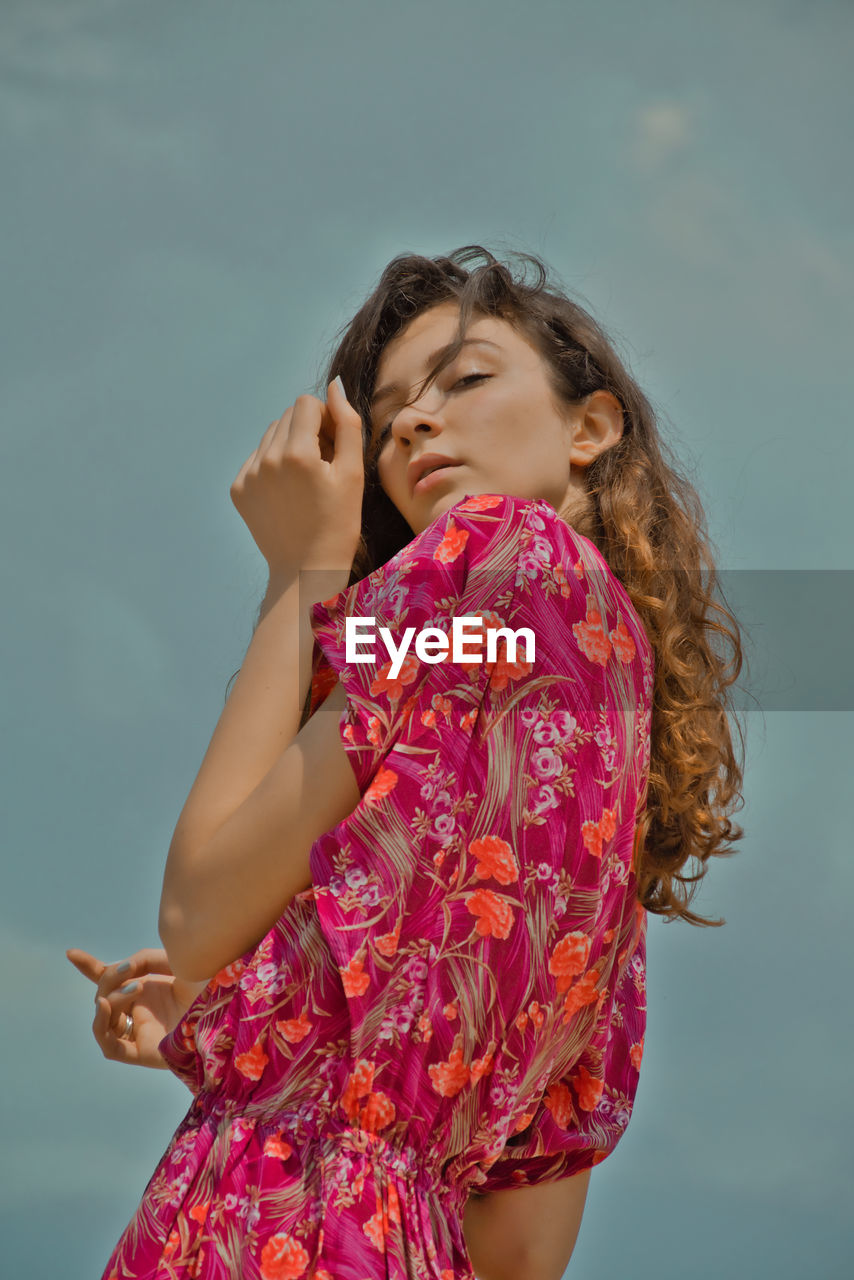 Low angle view of woman standing against the sky