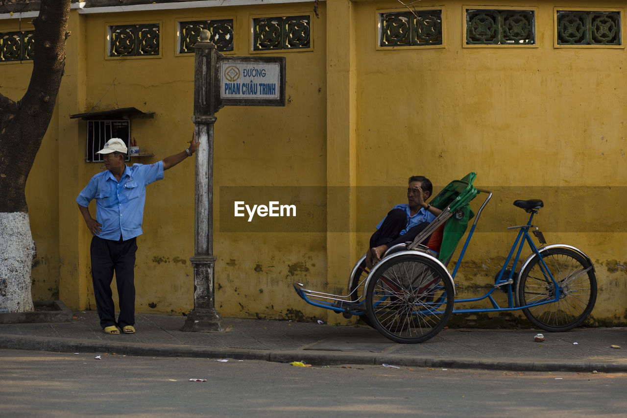 MAN WITH BICYCLE ON STREET