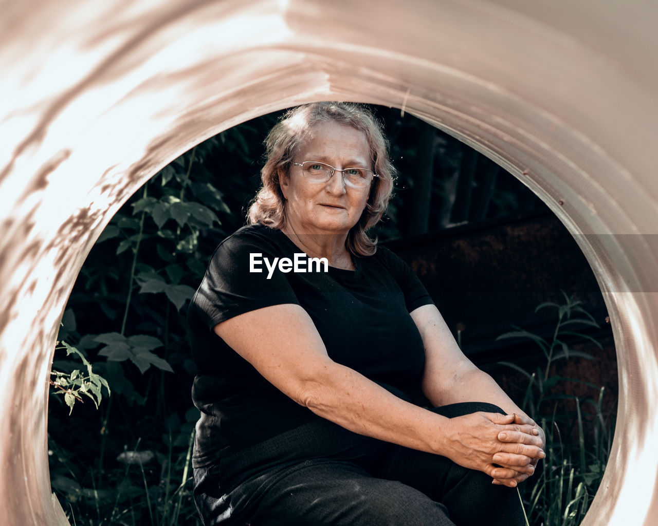 Portrait of elderly woman in glasses close-up on natural background. sunset light on face of senior