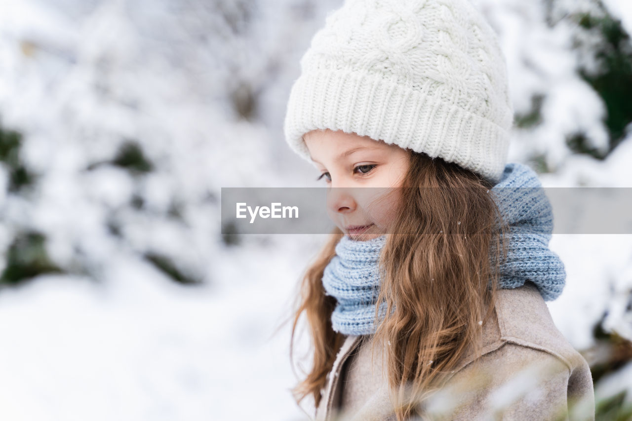 Cute girl on snow covered land during winter