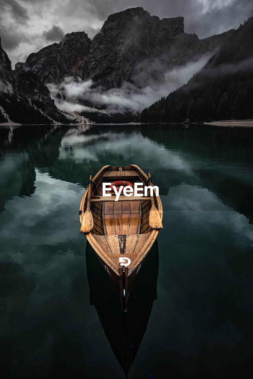 BOAT IN LAKE AGAINST MOUNTAINS