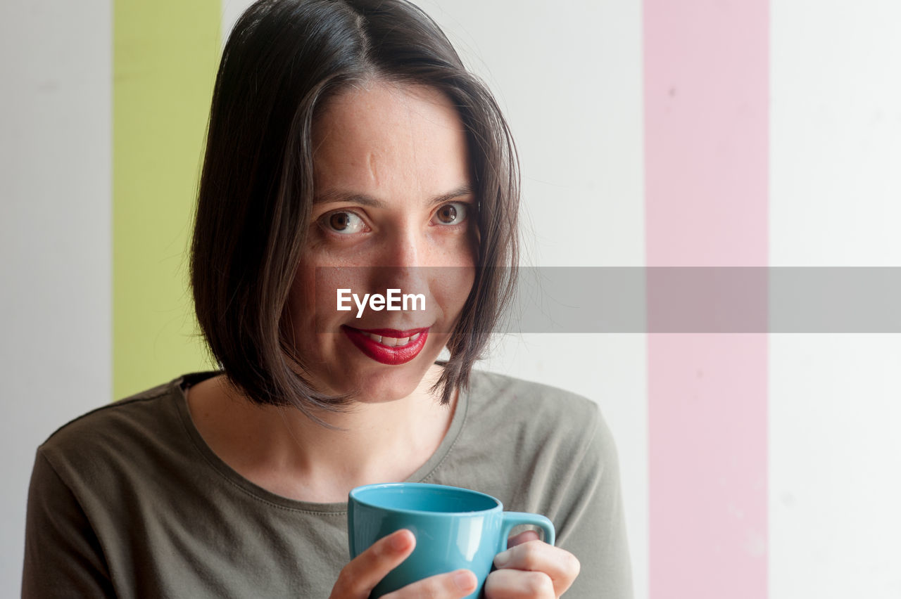 Portrait of smiling woman holding coffee cup