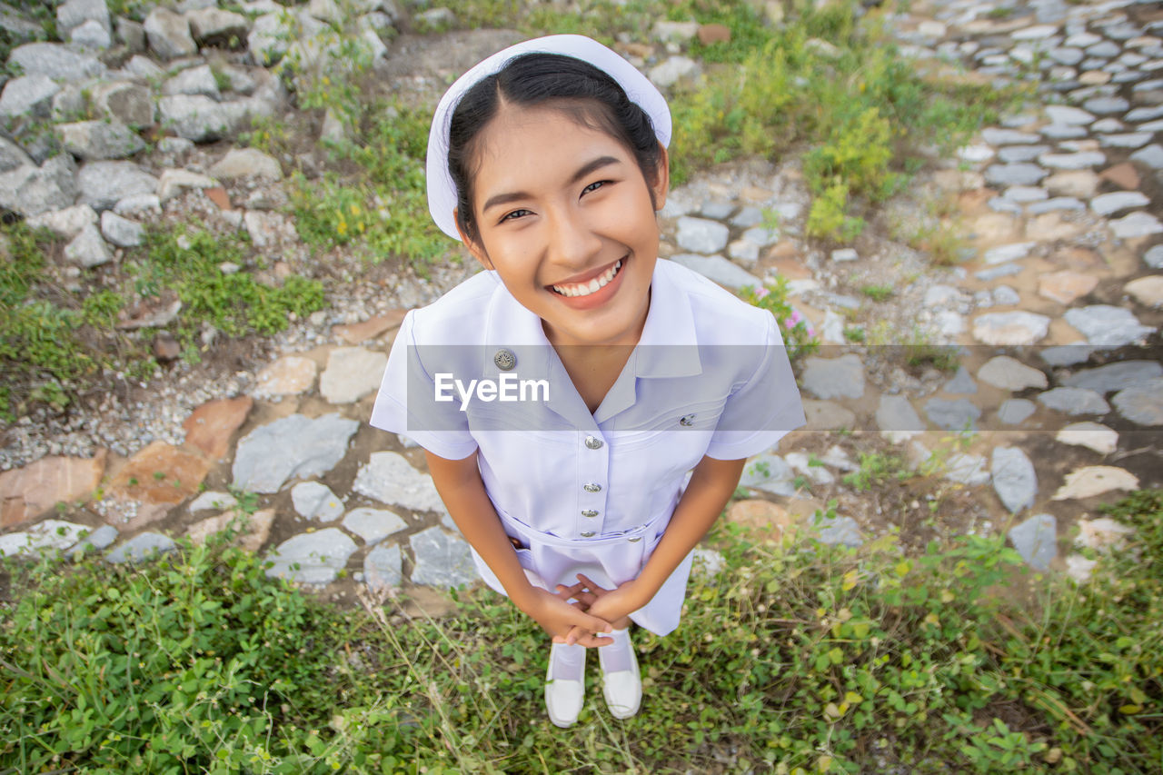 Smiling young nurse on field