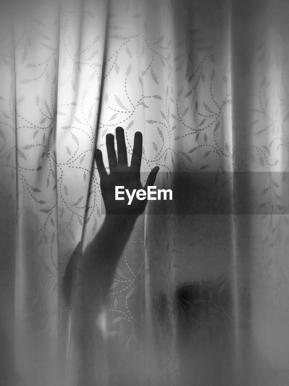 Hand behind curtain