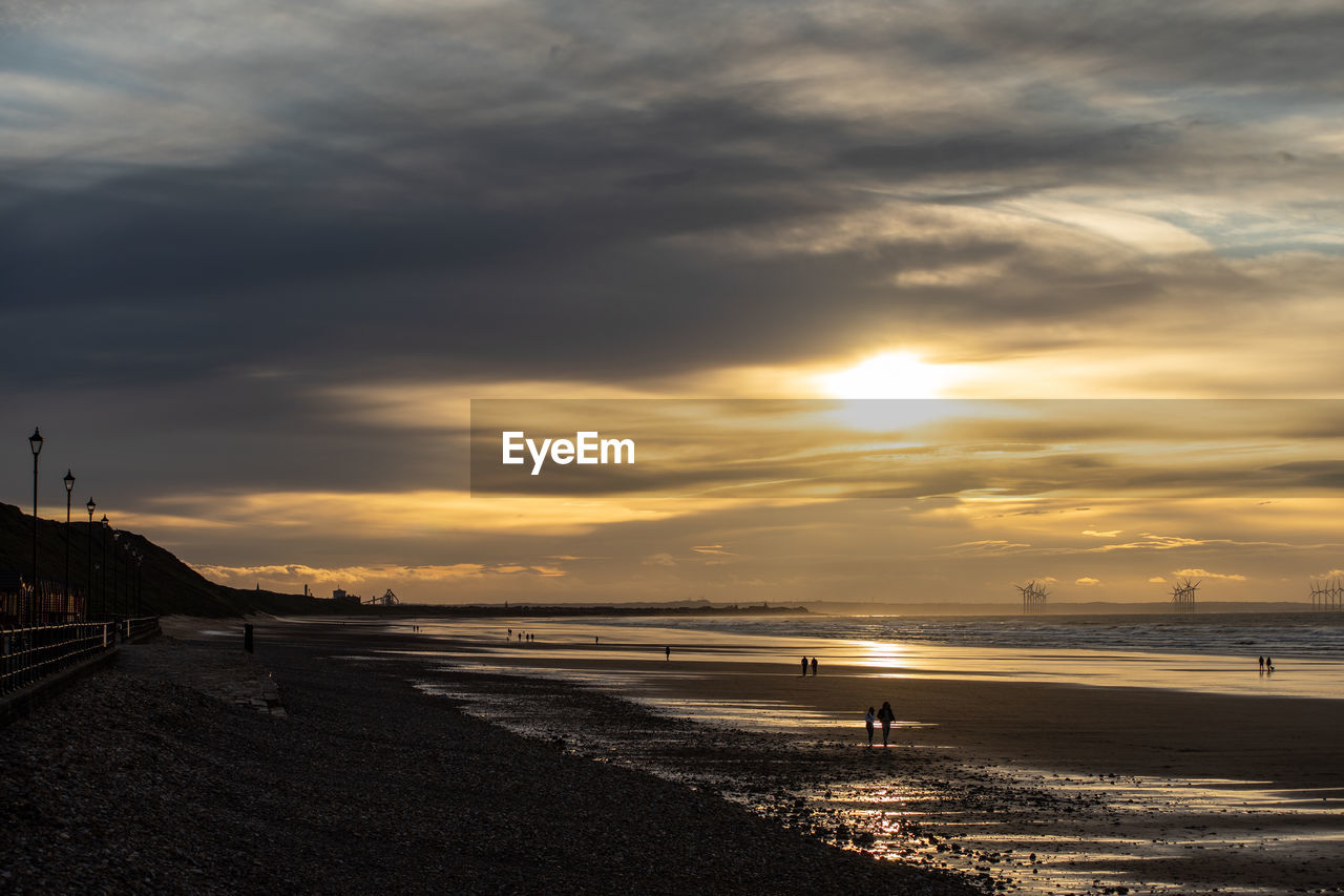 Scenic view of beach against sky during sunset