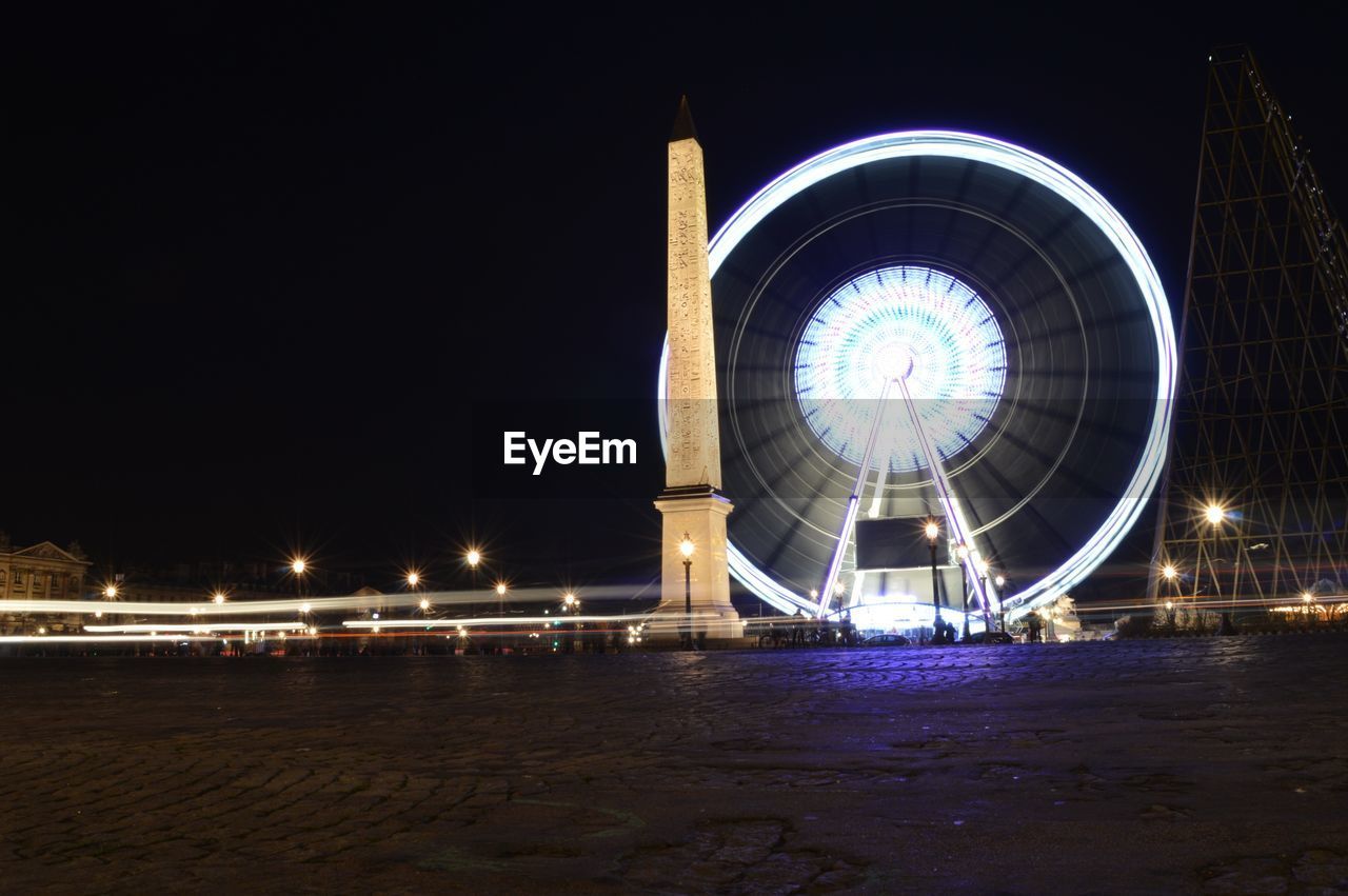 Illuminated roue de paris by obelisk of luxor at place de la concorde