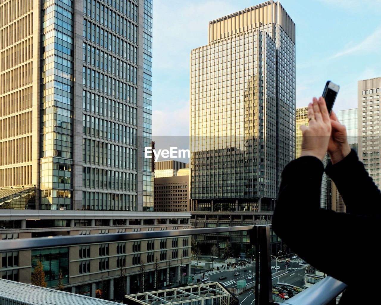 LOW ANGLE VIEW OF WOMAN AGAINST BUILDINGS IN CITY