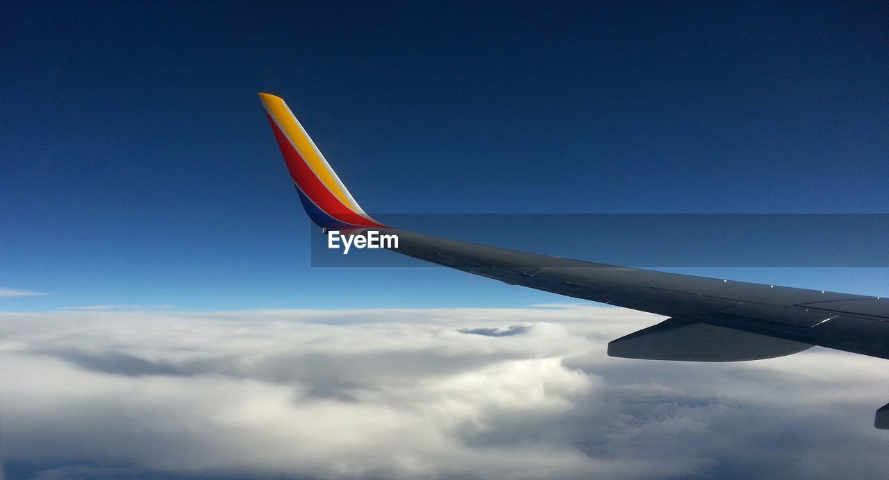 Cropped image of airplane flying in blue sky