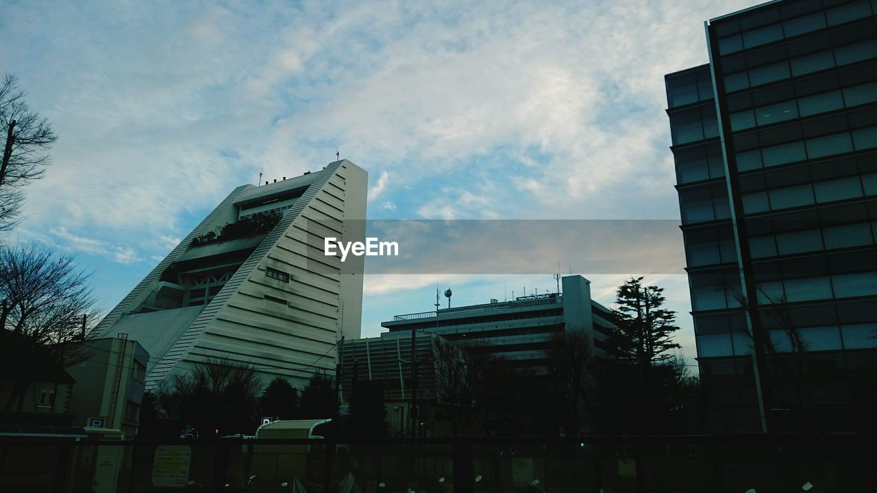 Low angle view of buildings against cloudy sky