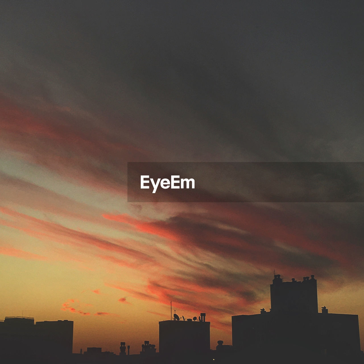 LOW ANGLE VIEW OF SILHOUETTE BUILDINGS AGAINST ORANGE SKY