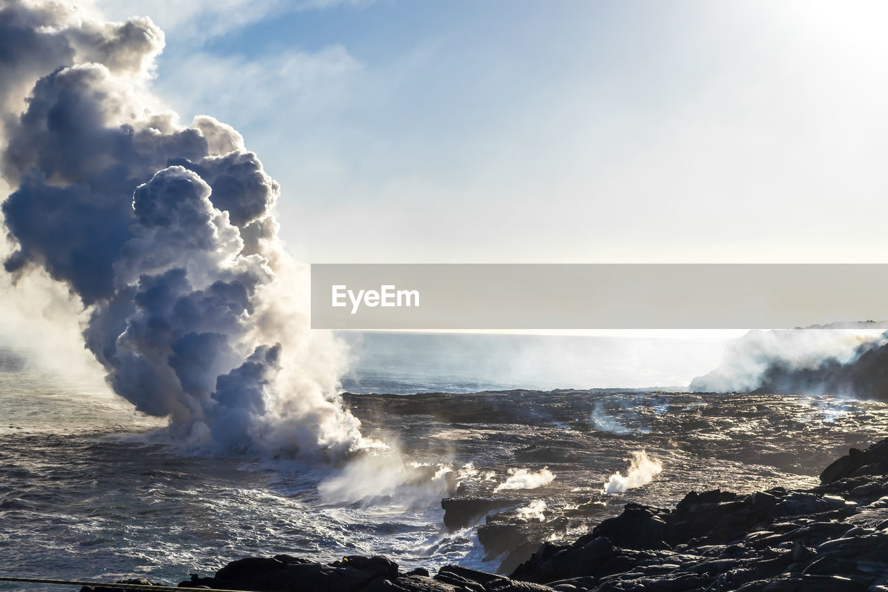 Eruption of a volcano on  hawaiian island on ocean. volcanic activity.  field of frozen black lava