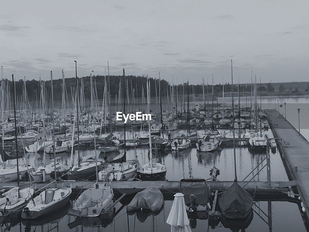 FISHING BOATS MOORED AT HARBOR AGAINST SKY