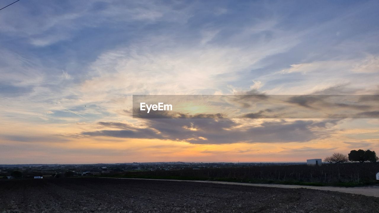 SCENIC VIEW OF AGRICULTURAL FIELD AGAINST SKY DURING SUNSET