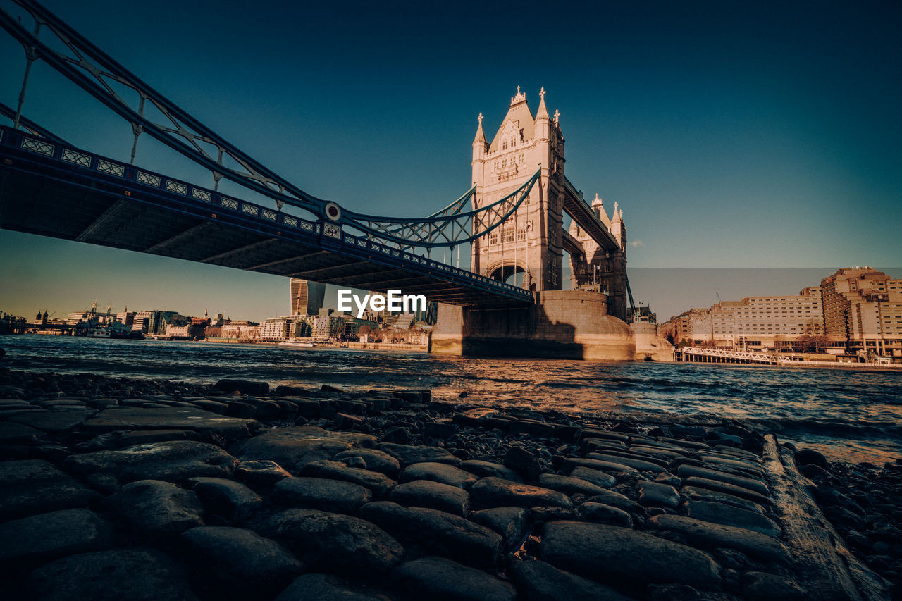 Low angle view of bridge against clear sky in city during sunset