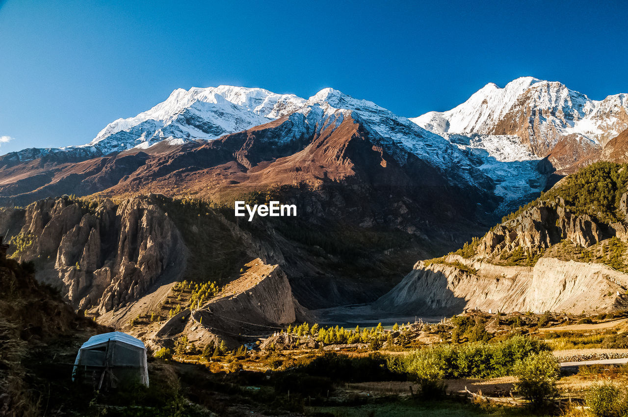 Panoramic view of snowcapped mountains against clear sky