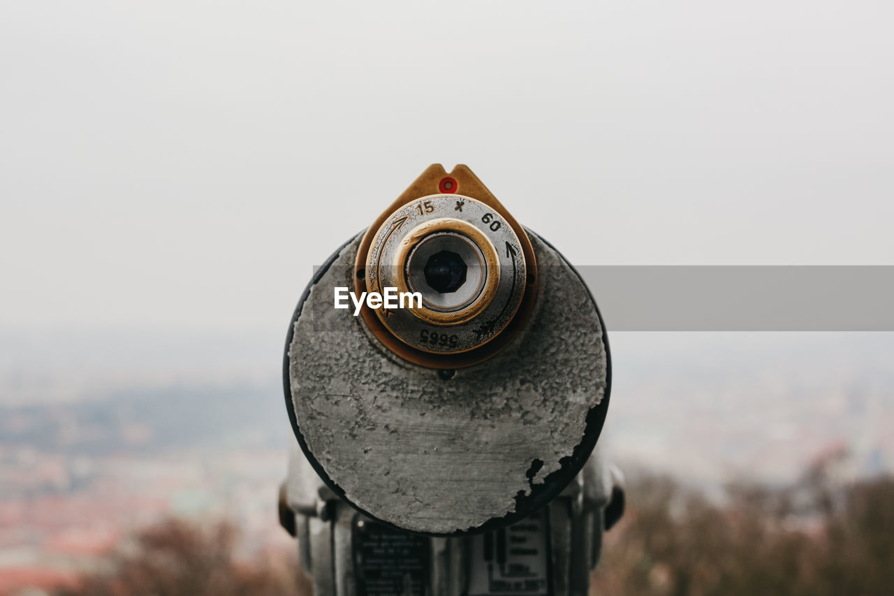 Close-up of coin-operated binoculars against cityscape in prague, czech republic.