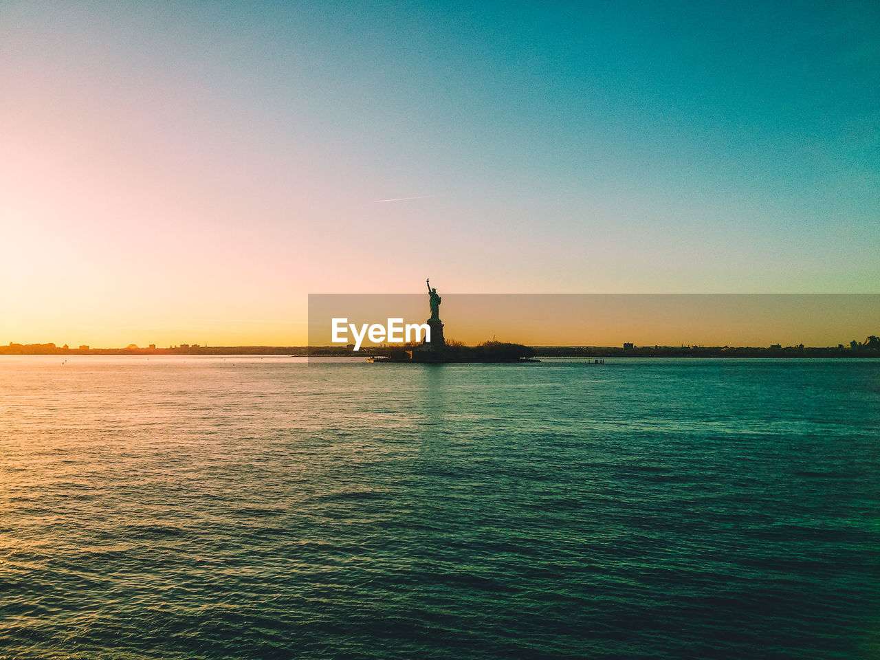 Statue of liberty in new york at sunset on a clear day