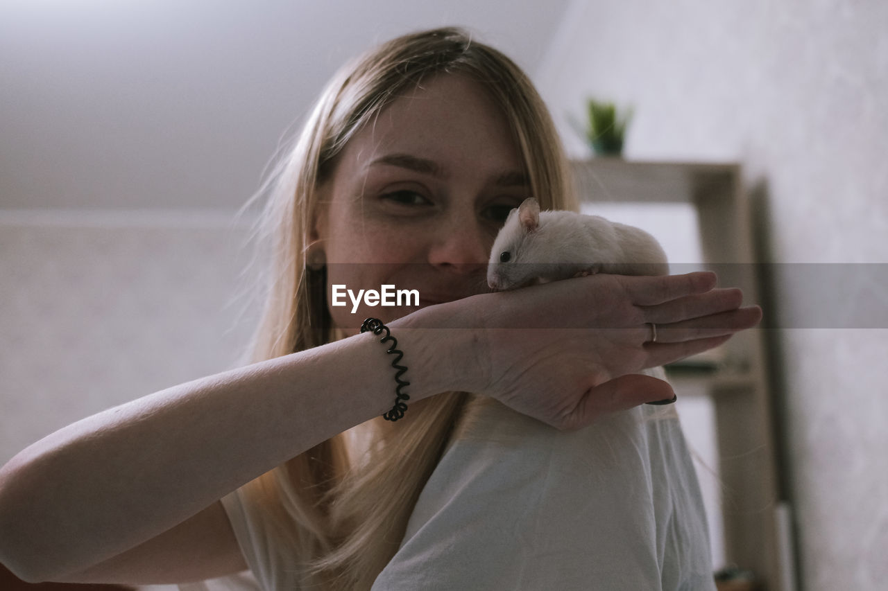 Happy girl with a small white syrian hamster. friendship between human and animal. 