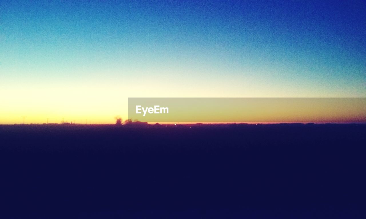 SILHOUETTE FIELD AGAINST CLEAR SKY DURING SUNSET