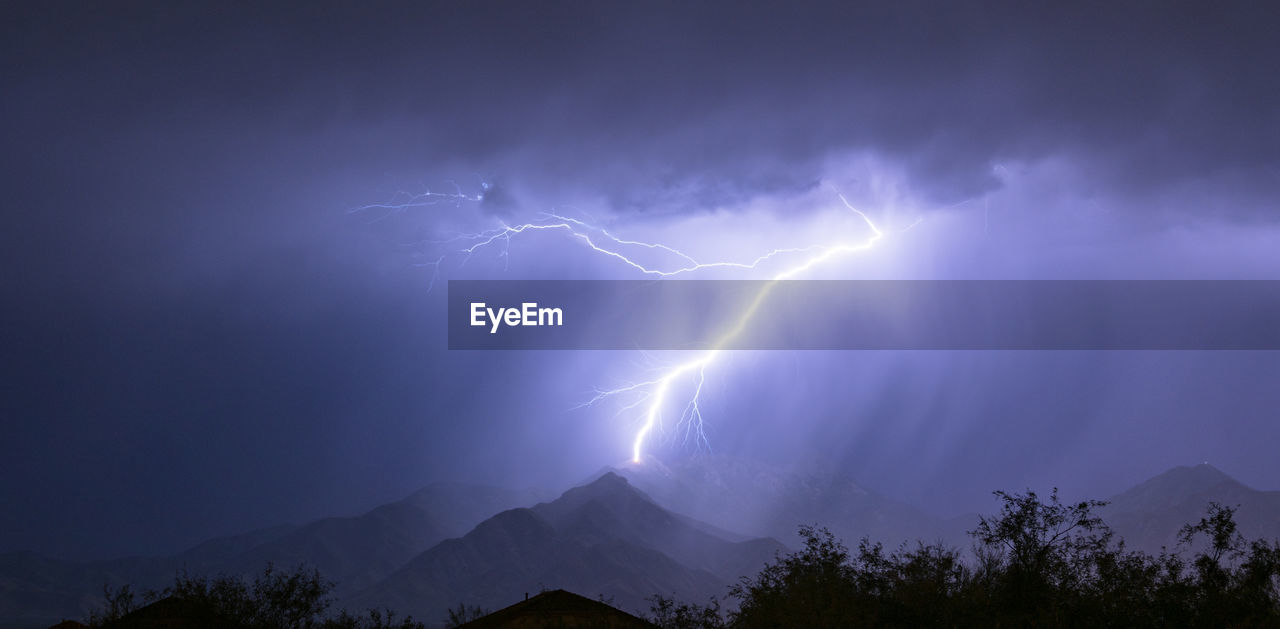 LOW ANGLE VIEW OF LIGHTNING OVER MOUNTAINS