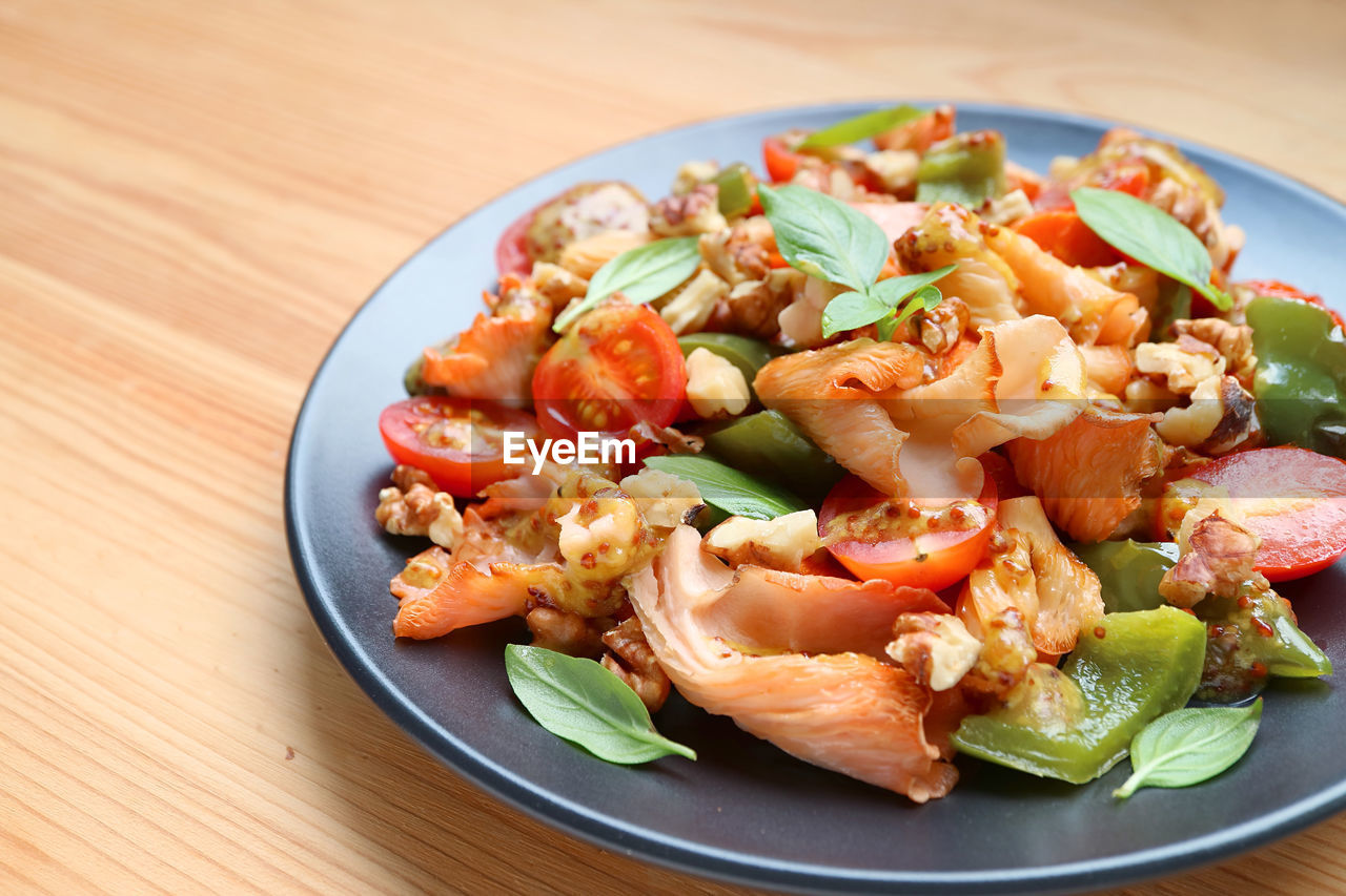 Plate of tasty and healthy sauteed pink oyster mushrooms with colorful vegetables