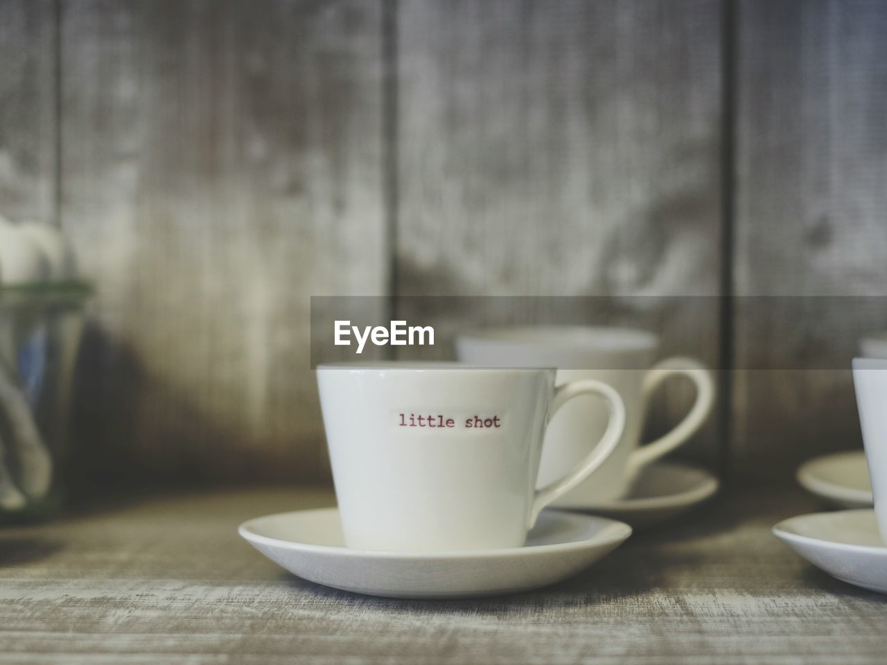Close-up of text on coffee cup on wooden flooring