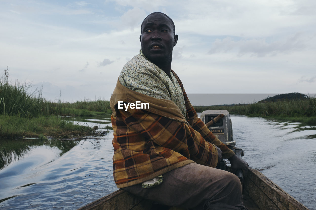 MAN STANDING ON RIVERBANK