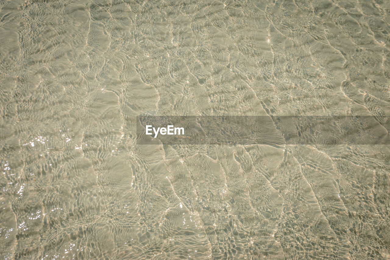 FULL FRAME SHOT OF RIPPLED WATER IN SAND