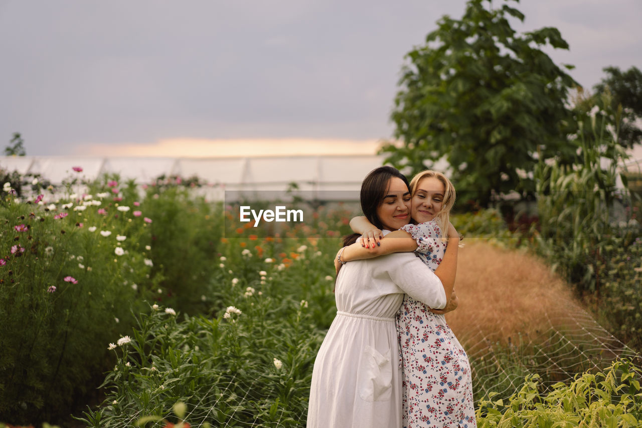 A young mother with a teenage daughter spends time in the garden. family holiday and togetherness.