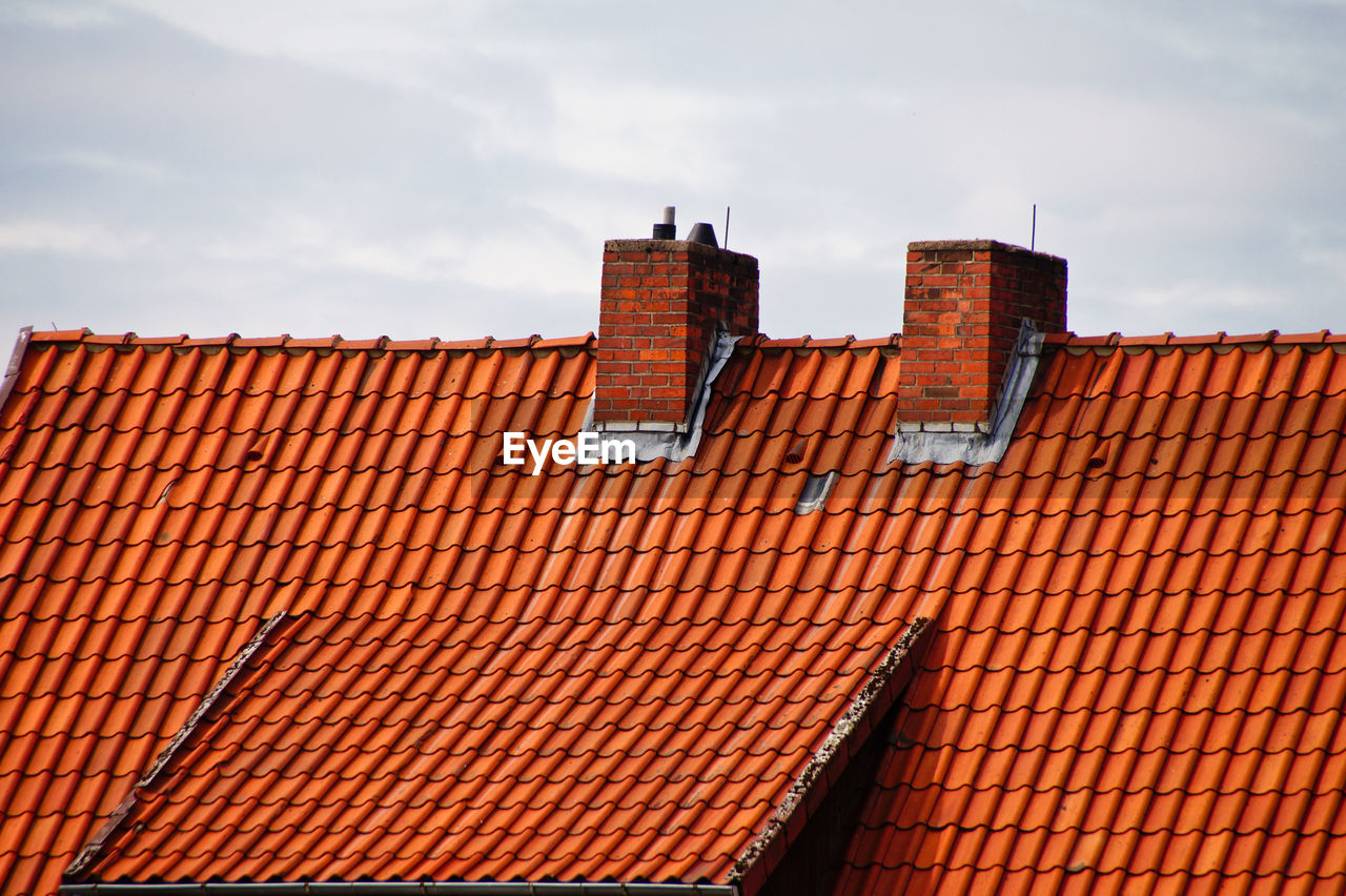 Roof tiles on house against sky