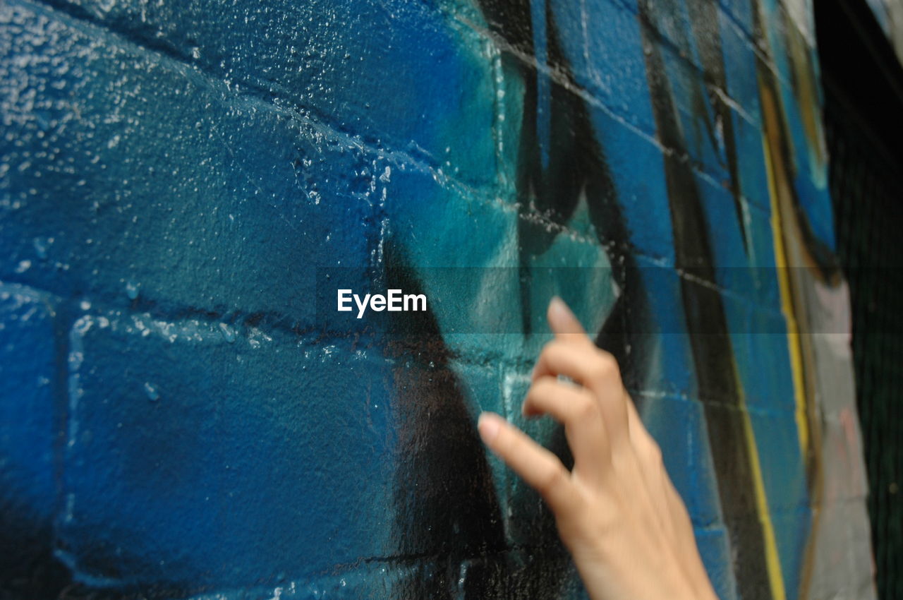 Close-up of person touching wall