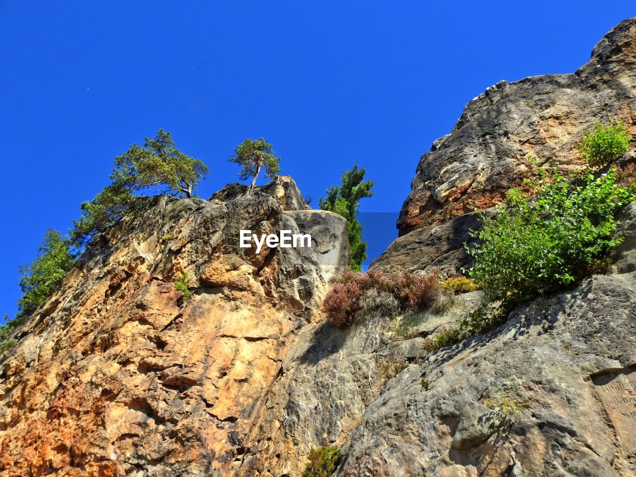 Low angle view of rock formation against clear blue sky