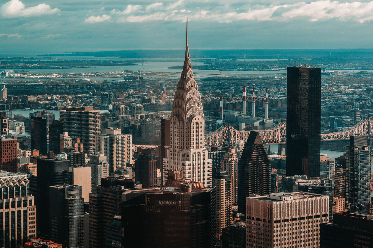 Aerial view of buildings in new york city against cloudy sky