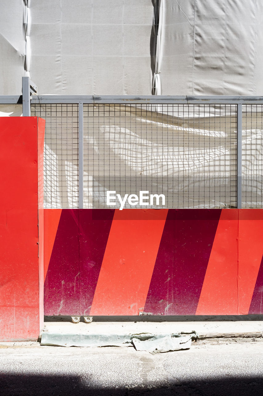 CLOSE-UP OF RED WALL WITH UMBRELLA