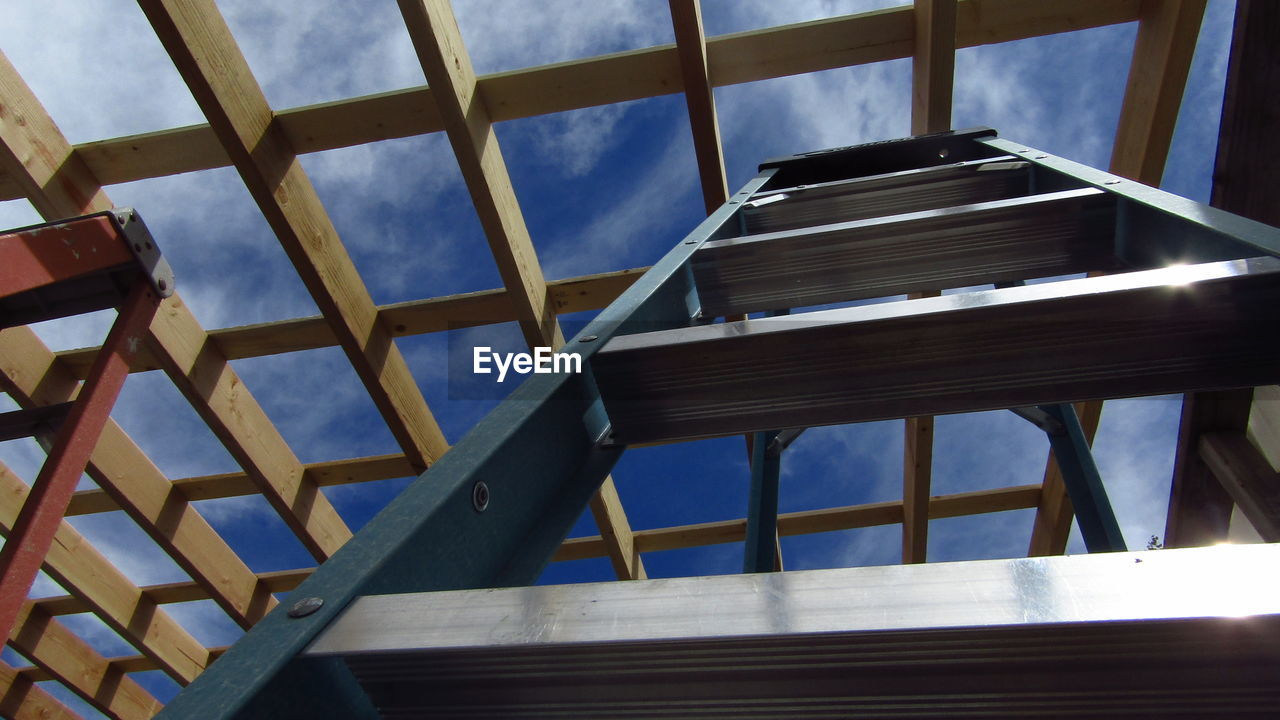 Low angle view of ladder and framing against sky