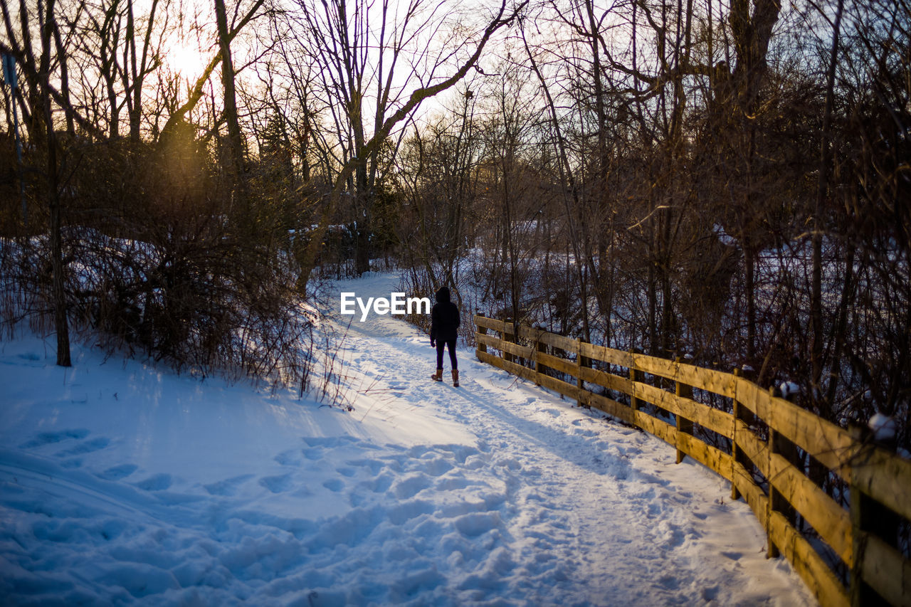 Woman walking on snow covered field