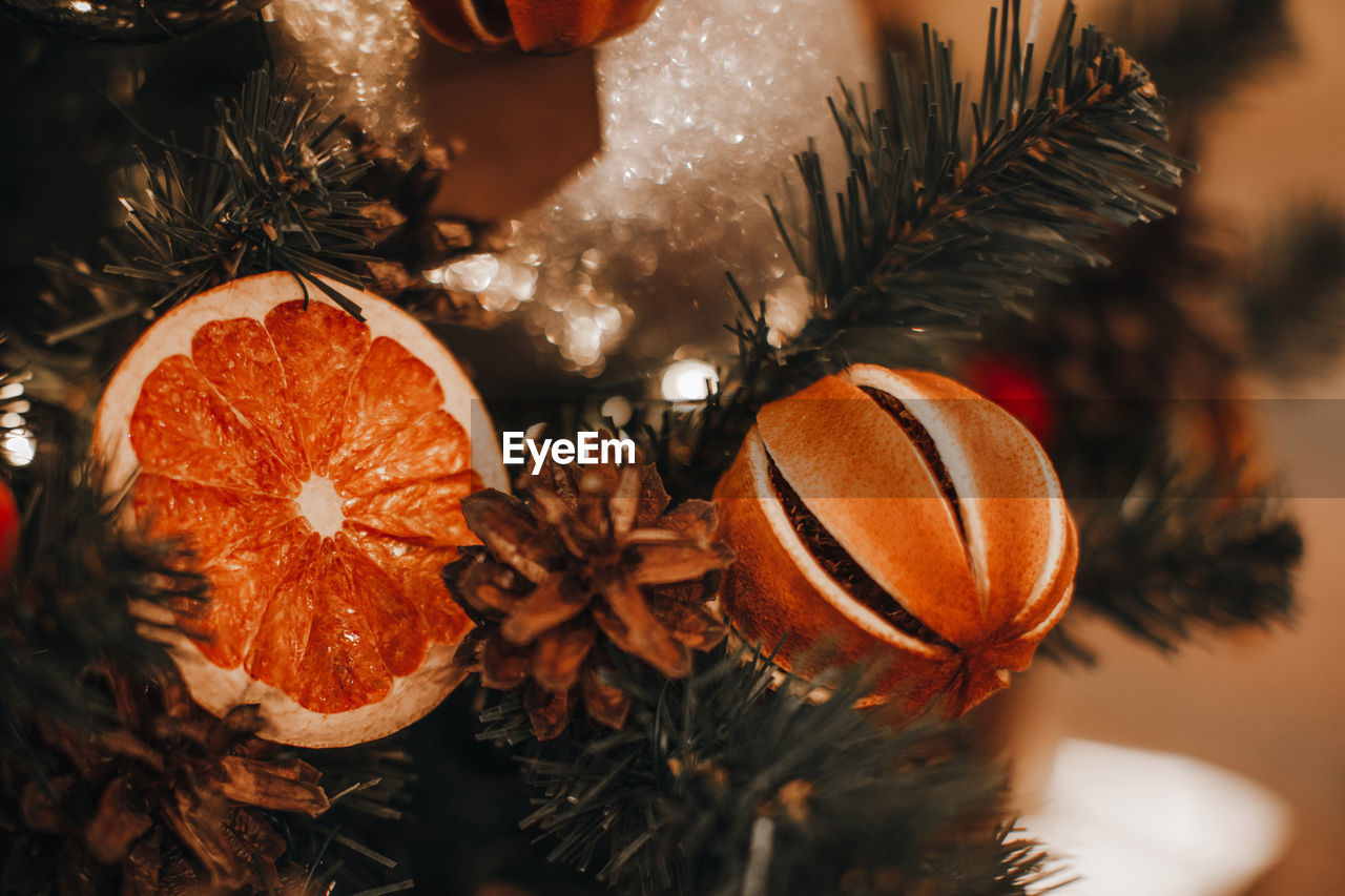 Creative christmas tree decorated with dry oranges, pine cones. magic cozy details, winter season