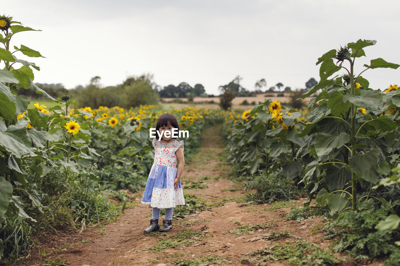 Full length portrait of girl standing on field