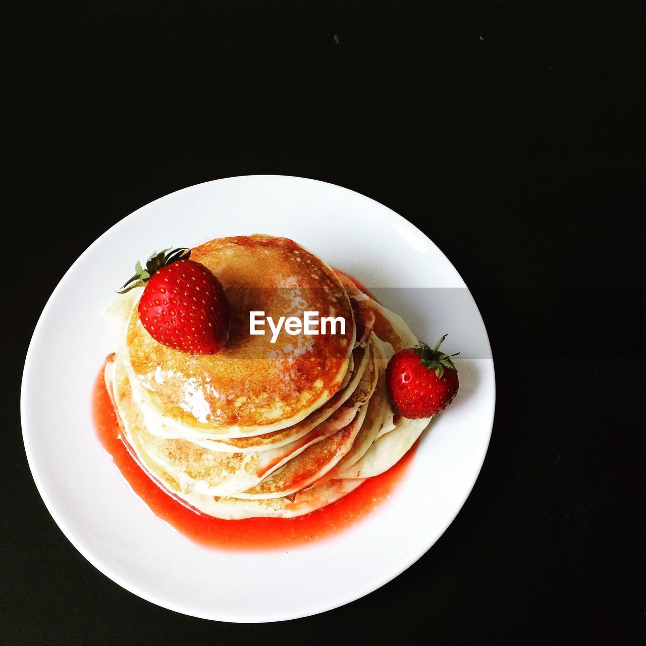 High angle view of pancakes served in plate on black background
