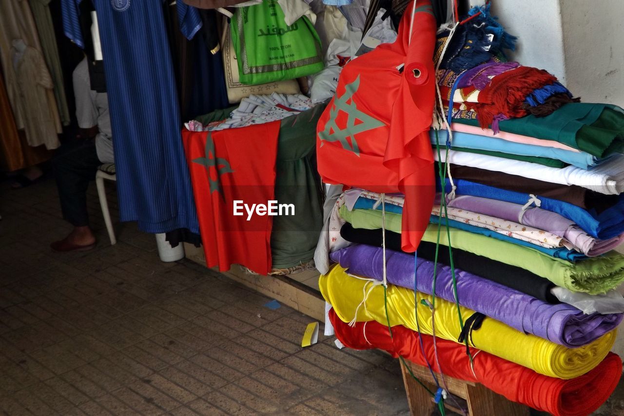 STACK OF MULTI COLORED UMBRELLAS HANGING ON SHELF AT HOME