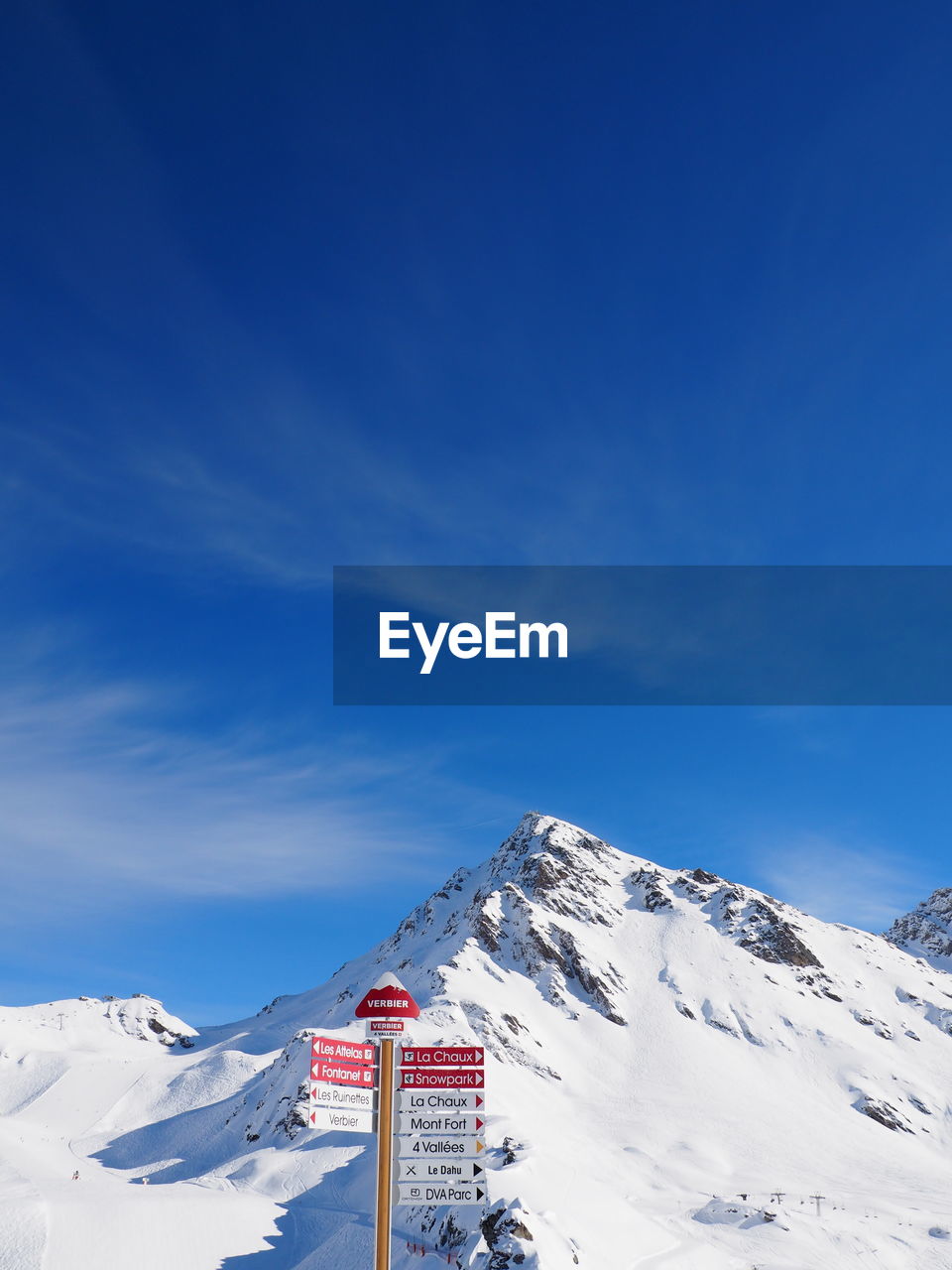 Signboard at ski resort against cloudy sky