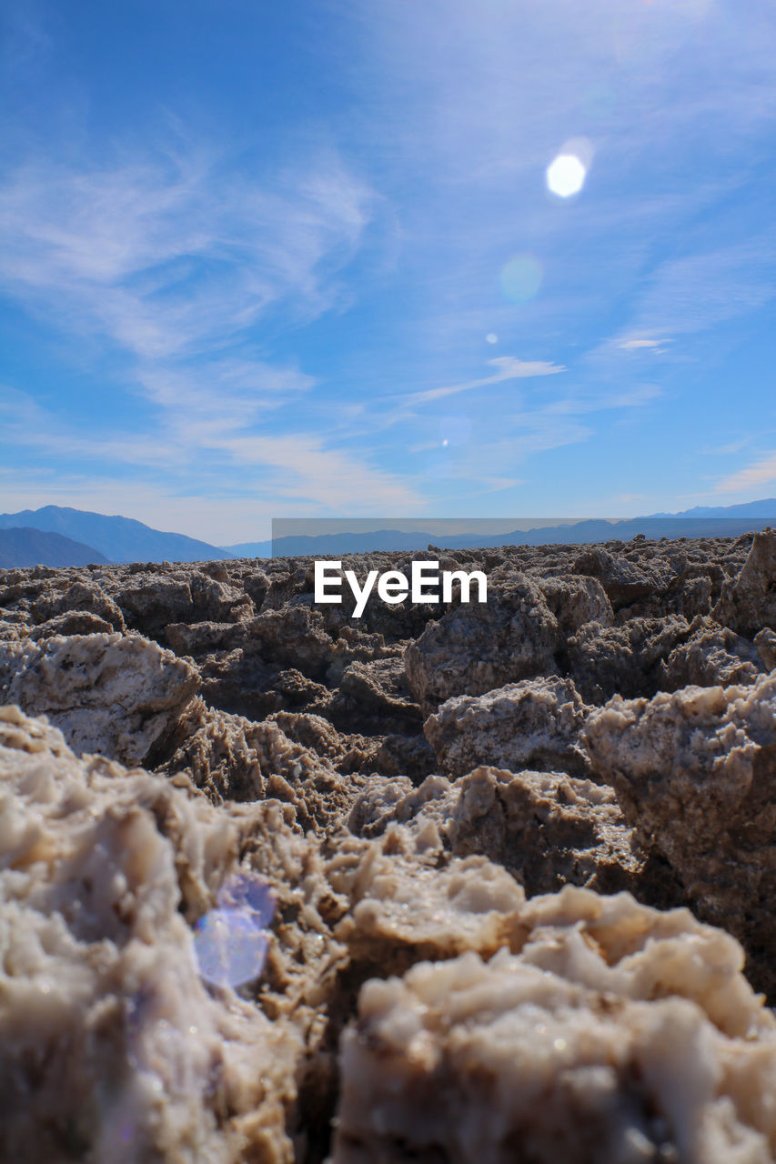 Rocks on landscape against blue sky