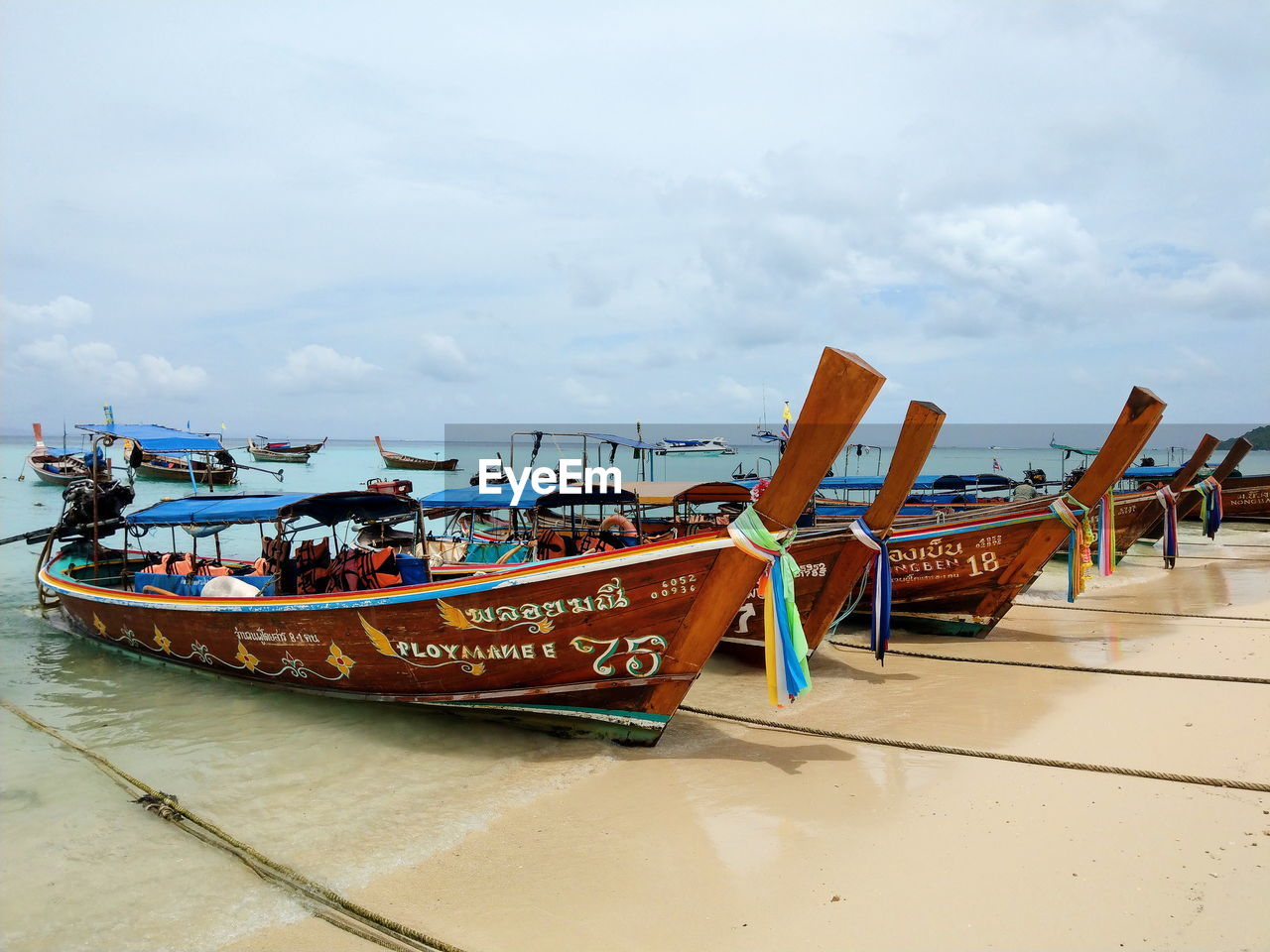 FISHING BOATS ON BEACH AGAINST SKY