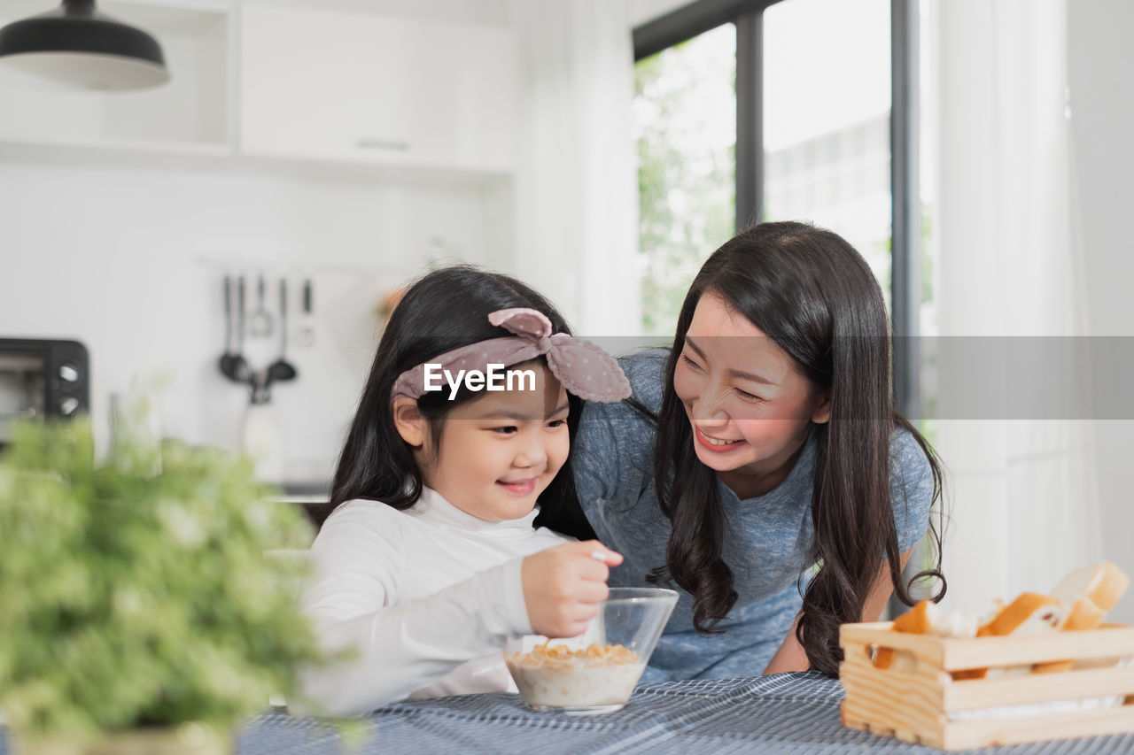 Smiling woman with daughter at home